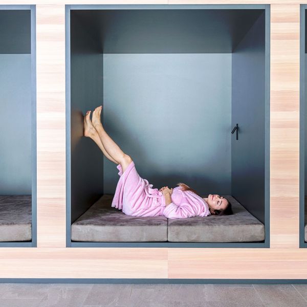 Contemporary wellness relaxation pods with grey cushioned seating alcoves and modern architectural design